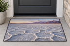 White polygonal salt crust before desert mountains printed on a complete flat rectangular doormat