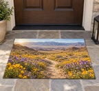 Yellow and purple desert flowers and a receding path toward arid mountains printed on a flat rectangular doormat