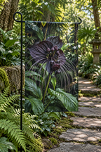 Dark bat flower with long whisker-like filaments before receding tropical foliage printed on a garden flag