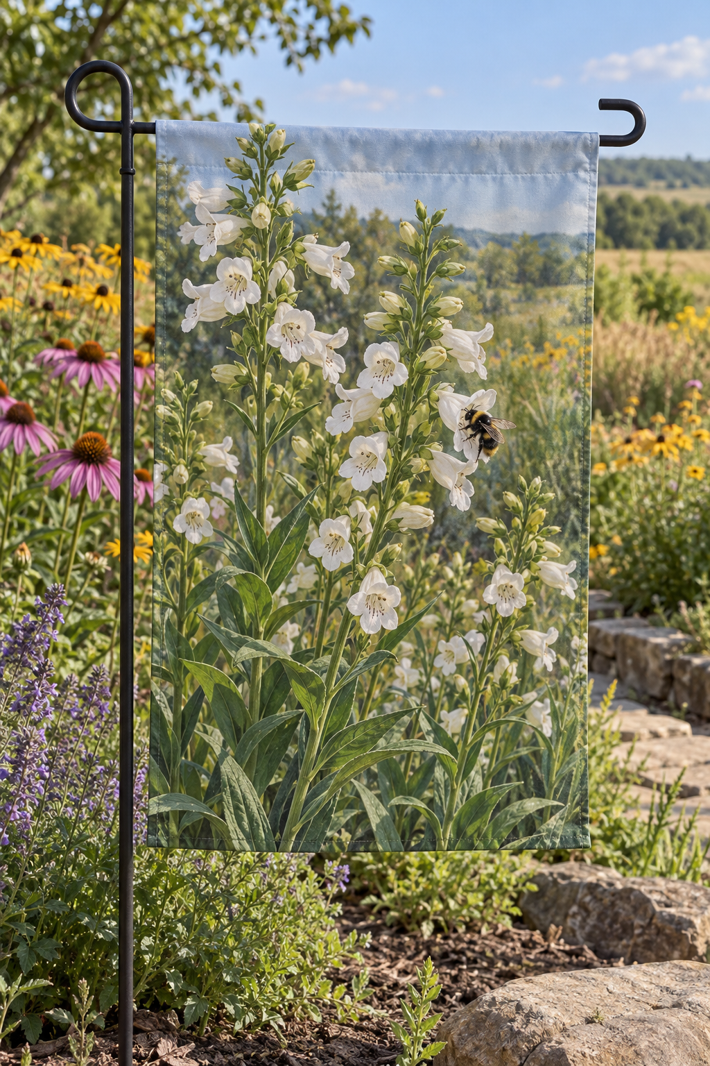 White tubular foxglove beardtongue flowers and bumblebee before a sunlit meadow printed on a complete rectangular garden flag with top sleeve
