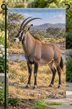 Roan antelope beside a deep wooded savanna waterway printed on a complete hemmed garden flag
