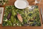 Green and purple finger limes with pearl-like pulp before a receding grove printed on a flat rectangular placemat