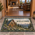 A-frame cabin and alpine wildflowers printed on a doormat in a warm timber room with a stone hearth.