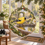 Complete clear-rim acrylic ornament with supported gold cord, leafy blossom edge and evergreen sprig around a goldfinch birdbath scene.