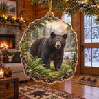 Complete acrylic ornament with supported gold cord, evergreen-and-root border and black bear in a forest clearing.