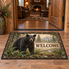 Complete rectangular doormat with correct WELCOME, black bear and fern clearing enclosed by root and stone motifs.