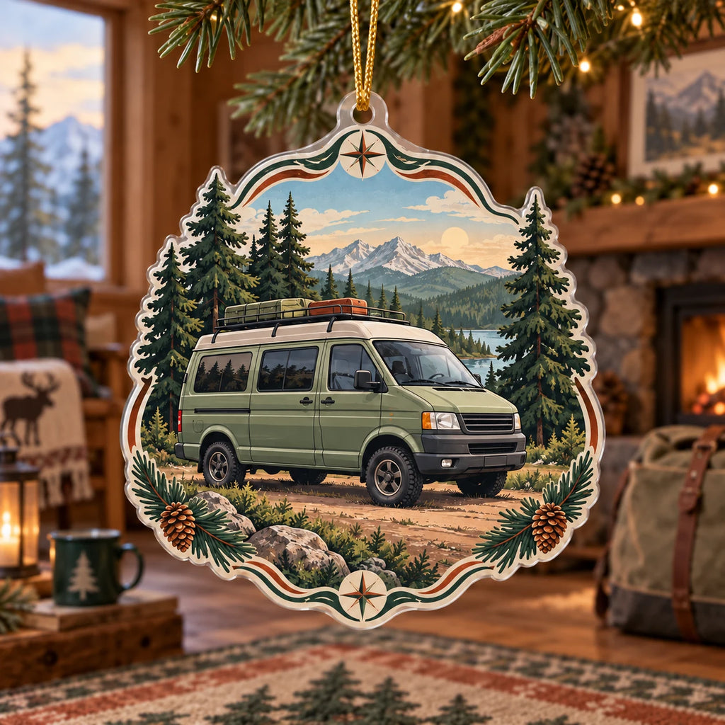 Sage camper van christmas ornament with pine forest, mountain lake and trail motifs in a rustic travel-inspired room.