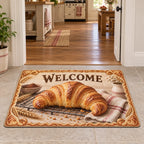 Croissant doormat with golden laminated pastry on cooling rack, striped linen, wheat accents and cozy baking kitchen.