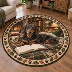 Full round rug with paw-and-oak-leaf ring; a black-and-tan dachshund rests beside a blank book and glasses.