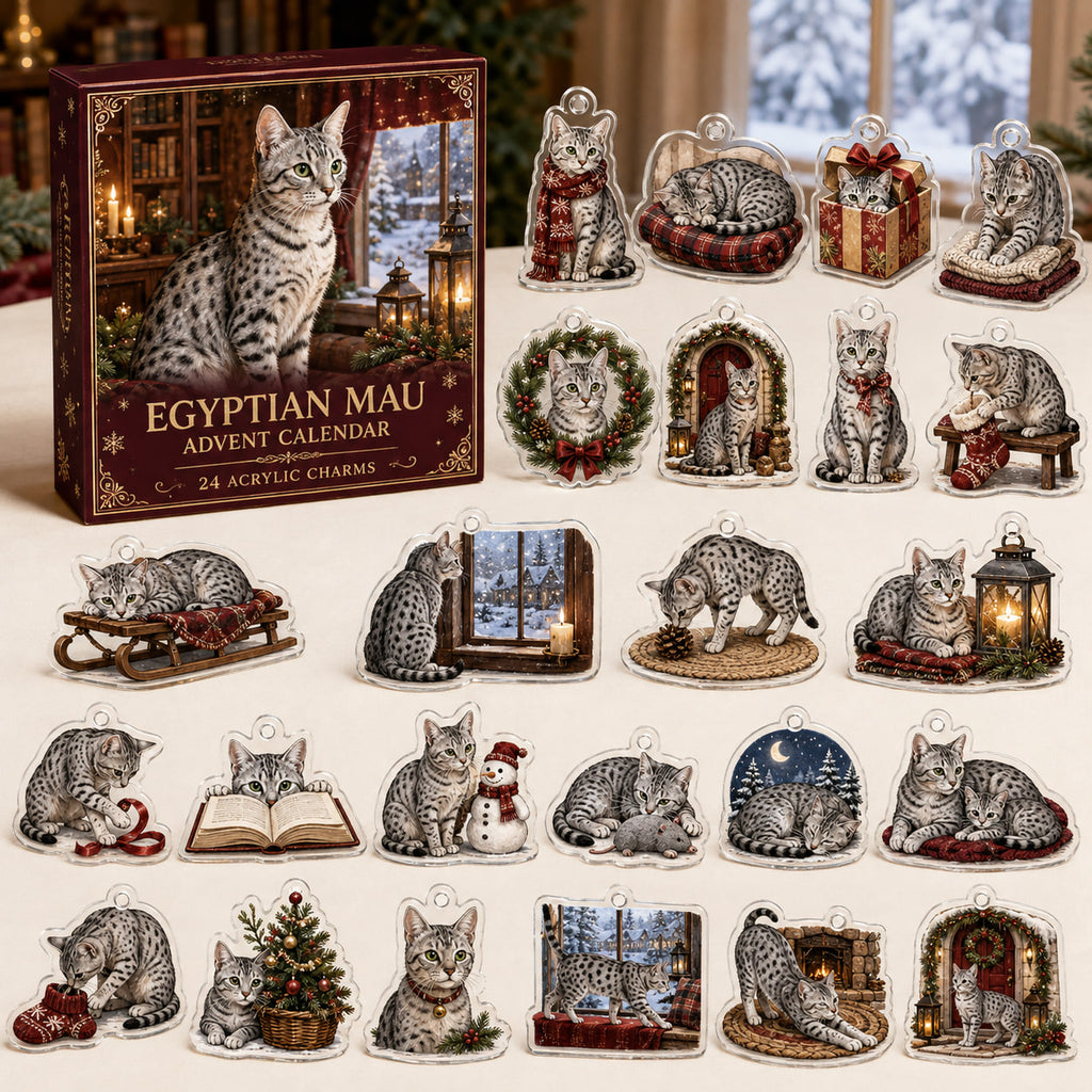 Egyptian Mau advent calendar box and 24 illustrated acrylic charms displayed on an ivory tabletop in a winter setting