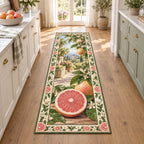 Grapefruit runner rug with pink cut fruit, whole grapefruit, glossy green leaves and cream botanical edging in a bright kitchen.