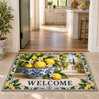 WELCOME doormat with lemons in a blue-white bowl and citrus blossom border at a bright interior doorway.