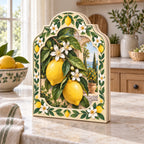 Wooden block with printed lemons, white blossoms and green garden-tile framing in a bright kitchen