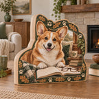 Red and white Pembroke corgi wooden block beside an open book and glasses with oak leaf and paw accents.