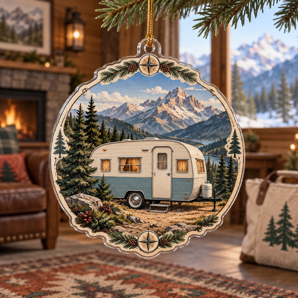 Cream-and-blue retro camper beneath mountain ridges printed on a christmas ornament in an outdoor-themed indoor room.