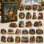 Somali Cat advent calendar box and 24 illustrated acrylic charms displayed on an ivory tabletop in a winter setting